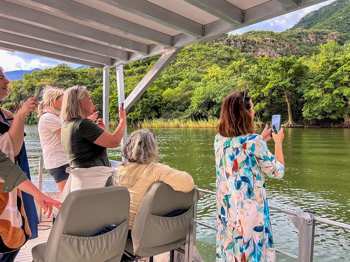 Ladies on a boat cruise taking content with their mobile phones