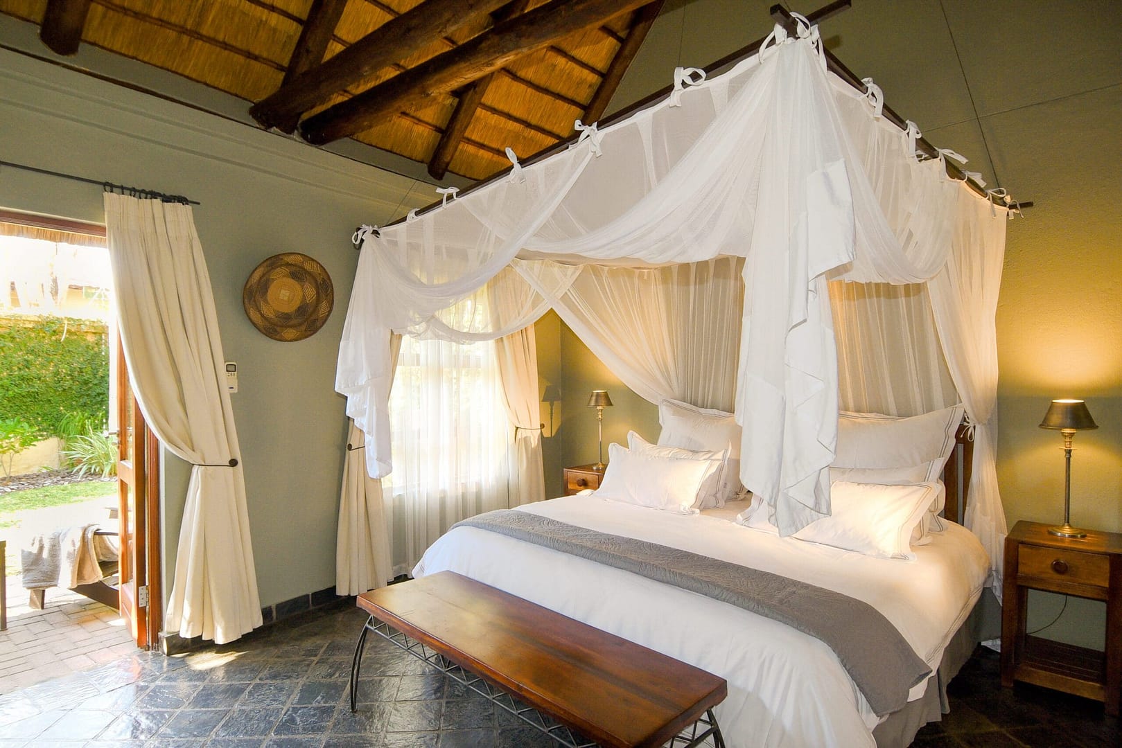 The luxury suite bedroom with draped canopy over the bed