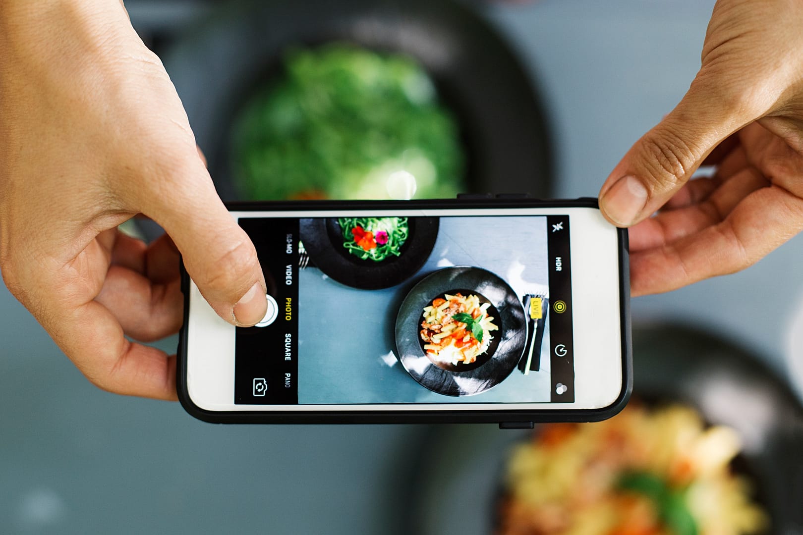 Top view of people using cellphone to take food photo