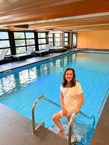 A lady standing in an indoor heated pool at Grächen
