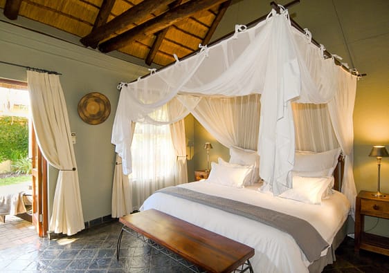 The luxury suite bedroom with draped canopy over the bed