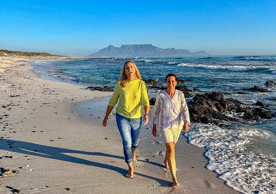 Two ladies walking along the beach with Table Mountain in the backdrop