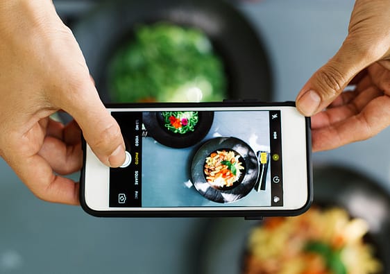 Top view of people using cellphone to take food photo