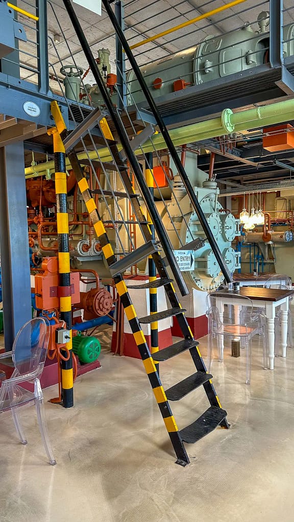 The whimsical interior of the Turbine Hotel. The old turbine engines and equipment is painted in bright colours to create a chic and modern atmosphere