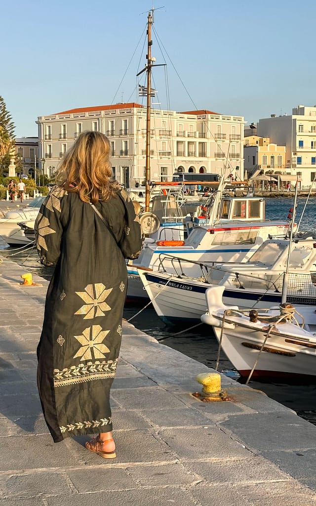 Lady walking at Tinos harbour in Greece. Frau spaziert am Hafen in Tinos