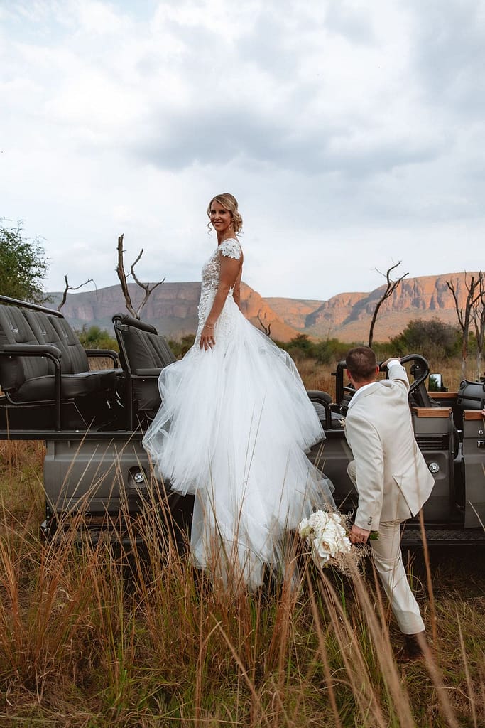 Bride standing on a game vehicle in the lowveld at a private game lodge