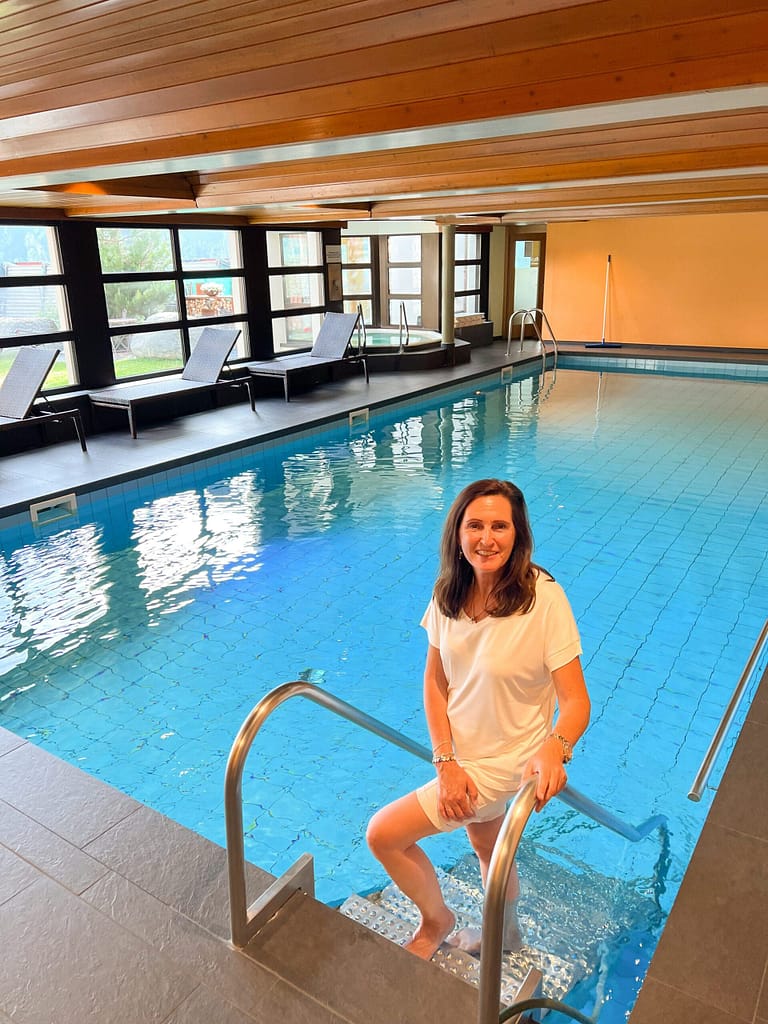 A lady standing in an indoor heated pool at Grächen