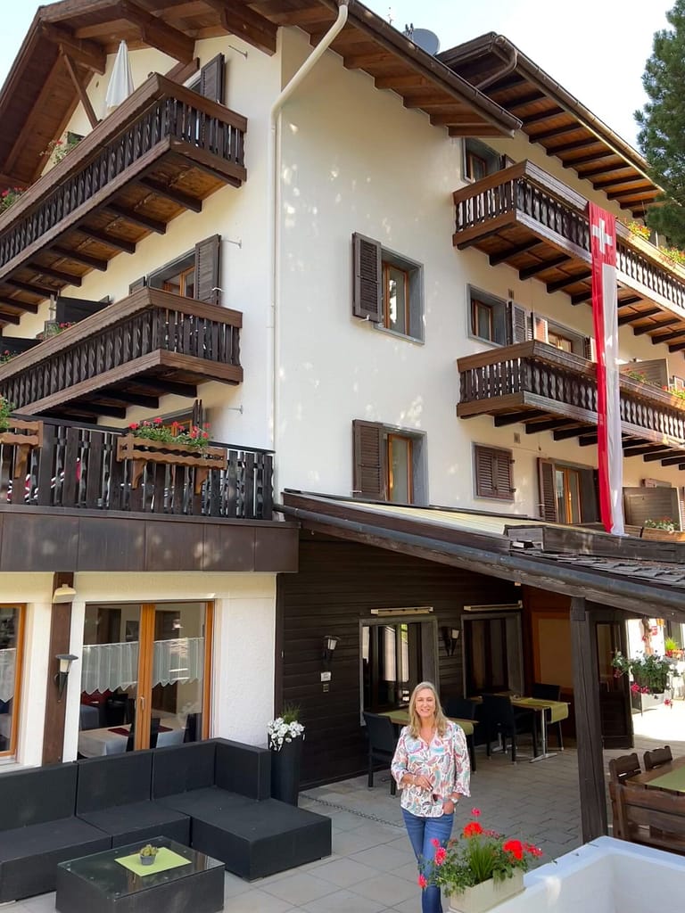 Bernie standing in front of a wooden hotel in Grächen Switzerland