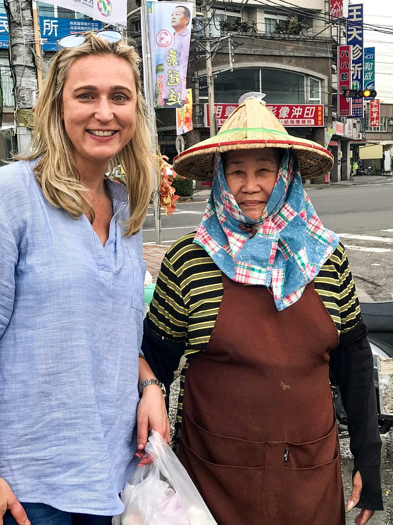 Bernie enjoying street food in Taiwan which is part of the Asian continent and talking to some locals