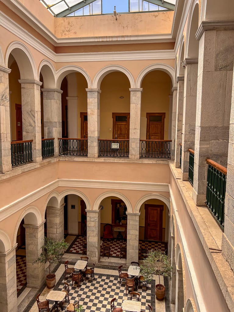 View from the courtyard below of the City Hall in Ermoupoli with impressive grand piano and checkered tiles in Syros