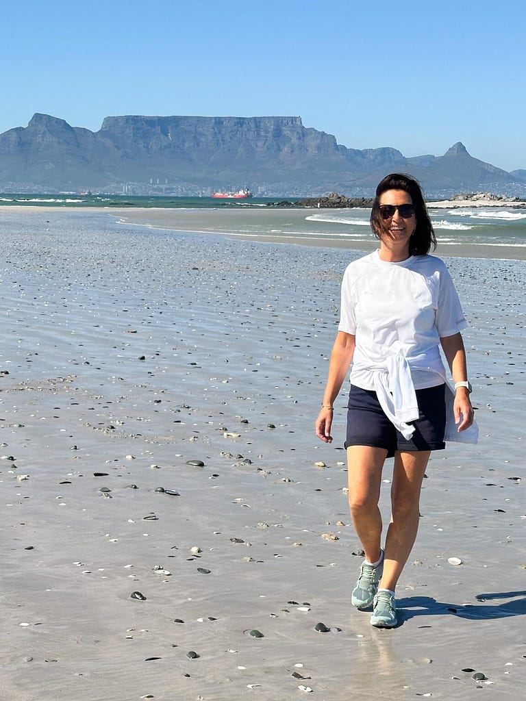 Lady walks on Bloubergstrand beach, Big Bay, Table Mountain