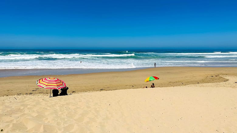 Sedgefield beach, Garden Route, South Africa, Soft sandy white beach with holiday makers sitting on the beach under a umbrelle