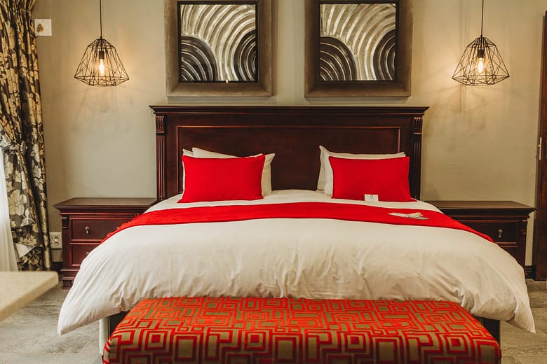 Double bed with lovely natural colours bedding and a touch of orange and red