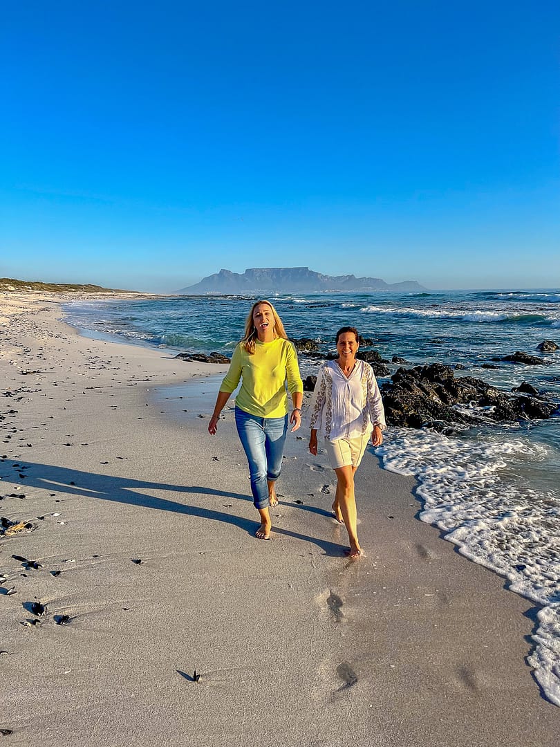 Two ladies walking along the beach with Table Mountain in the backdrop