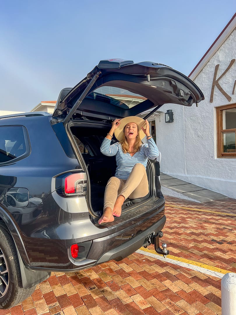 Lady sitting in the boot of a Ford Ranger in front of a resturant in Melkbosstrand